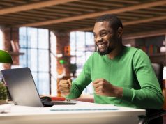 Where Nigerians Are Earning Money Online Using AI Tools (And How You Can Too) joyful-man-home-happily-shaking-fists-ecstatic-1-scaled