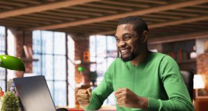 Where Nigerians Are Earning Money Online Using AI Tools (And How You Can Too) joyful-man-home-happily-shaking-fists-ecstatic-1-scaled