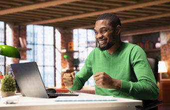 Where Nigerians Are Earning Money Online Using AI Tools (And How You Can Too) joyful-man-home-happily-shaking-fists-ecstatic-1-scaled