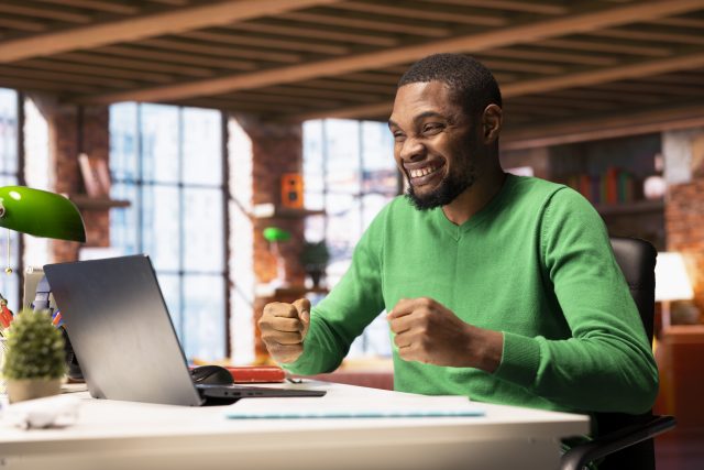 Where Nigerians Are Earning Money Online Using AI Tools (And How You Can Too) joyful-man-home-happily-shaking-fists-ecstatic-1-scaled