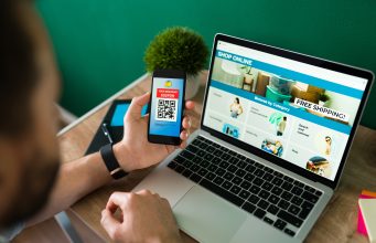 How to Start an Ecommerce Business Without Capital young-man-using-discount-coupon-his-smartphone-some-online-shopping-laptop-scaled